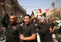 イラク南部バスラで営まれたイスラム教シーア派系民兵組織「人民動員隊」のベテラン狙撃手アブ・タフシン・サルヒ氏の葬儀でサルヒ氏のひつぎを運ぶ参列者ら（2017年9月30日撮影）。(c)AFP/HAIDAR MOHAMMED ALIALI