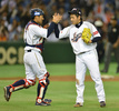 第3回ワールド・ベースボール・クラシック（2013 World Baseball Classic、WBC）は12日、東京で2次ラウンドの1位決定戦が行われ、大会3連覇を狙う日本は10-6でオランダを下し、2次ラウンド首位通過を決めた。

試合に勝利し喜び合う日本の相川亮二（Ryoji Aikawa、左）と牧田和久（Kazuhisa Makita、2013年3月12日撮影）。(c)AFP/KAZUHIRO NOGI