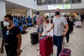 フィジー・ナンディの空港に到着し、民族衣装を着た人々に迎えられる観光客（2021年12月1日撮影）。(c)Leon LORD / AFP