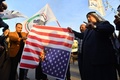 米軍による武装組織「神の党旅団（カタイブ・ヒズボラ）」の拠点空爆に抗議し、米国旗を燃やすイラク市民ら（2019年12月30日撮影）。(c)Haidar HAMDANI / AFP