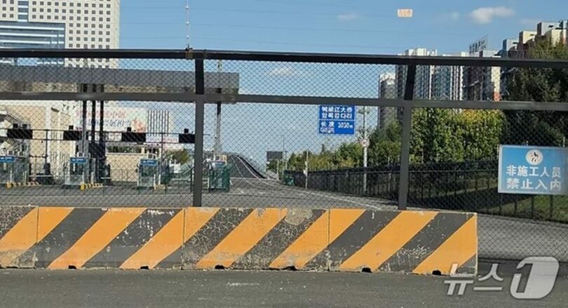 5日午後、中国遼寧省丹東市にある新鴨緑江大橋の中国側進入路。フェンスと遮断設備で封鎖され、「工事関係者以外立ち入り禁止」と書かれた案内板が設置されている(c)news1