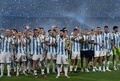 サッカー国際親善試合、アルゼンチン対キュラソー。試合後に行われたW杯カタール大会優勝の祝勝セレモニーで、トロフィーのレプリカを手に客席へ手を振るアルゼンチンのリオネル・メッシ（中央、2023年3月28日撮影）。(c)JUAN MABROMATA/ AFP