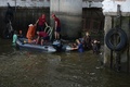 タイの首都バンコク中心部の高架鉄道BTSのサパーンタクシン駅近くで発生した爆発事件の捜査のため、ポンプを使って現場近くの運河から水を抜く当局者ら（2015年8月18日撮影）。(c)AFP/Christophe ARCHAMBAULT