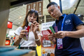 コーヒー産業館で出展業者（右）にコーヒーの包装設備について尋ねるバイヤー（2024年7月24日撮影）。(c)Xinhua News