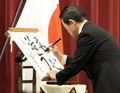 首相官邸で行った年頭の記者会見中に筆で「安心活力」と書く麻生太郎（Taro Aso）首相（2009年1月4日撮影）。(c)AFP/TOSHIFUMI KITAMURA