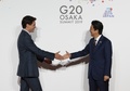 大阪で開催中の20か国・地域（G20）首脳会議の歓迎行事で、カナダのジャスティン・トルドー首相（左）を迎える安倍晋三首相（右、2019年6月28日撮影）。(c)KIM KYUNG-HOON / POOL / AFP