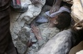シリア・アレッポの反体制派が掌握するアルファルドゥス地区で、がれきの下から救出される少年（2016年10月11日撮影）。(c)AFP/THAER MOHAMMED