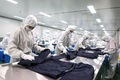 北京冬季五輪の関係者が着用する防護服を作る作業員。中国・山東省浜州市で（2022年1月27日撮影）。(c)AFP