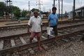 インド、ニューデリーにある鉄道駅の近くで、屋外排せつ場所となっている区域の線路上を歩く人々（2019年9月27日撮影）。(c)Prakash SINGH / AFP