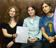 モスクワ（Moscow）の裁判所で、判決書を見せるロシアのパンクバンド「プッシー・ライオット（Pussy Riot）」のメンバー3人（2012年8月17日撮影）。(c)AFP