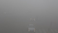 スモッグに覆われた中国東北部・黒竜江（Heilongjiang）省ハルビン（Harbin）で、通勤中の自動車（中央）と歩行者（右下、2013年10月21日撮影）。(c)AFP