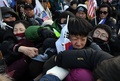 韓国・江陵での北朝鮮楽団の公演を前に行われた抗議デモで、警官ともみあいになる参加者ら（2018年2月8日撮影）。(c)AFP PHOTO / JUNG Yeon-Je