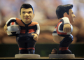 　スペイン・カタルーニャ（Catalonia）地方で、今年もクリスマス恒例の排便人形「カガネル（Caganer、「排便」の意）がお目見えした。カタルーニャでは、クリスマスシーズンになると有名人が排泄する姿を模した陶器の人形を自宅内に隠し、招待客に探させるのが恒例行事となっている。18世紀から続く風習で、カガネルは翌年の豊穣（ほうじょう）、希望、繁栄の象徴とされている。

　写真は、バルセロナ（Barcelona）のクリスマス市に登場した、二輪ロードレースMotoGPのスペイン人ライダー、ダニエル・ペドロサ（Dani Pedrosa）選手のカガネル（2009年12月21日撮影）。(c)AFP/LLUIS GENE