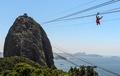 ブラジル・リオデジャネイロ（Rio de Janeiro）で、パン・デ・アスーカル山（Pao de Acucar）にあるロープエーのワイヤロープを滑車で滑り降りるサンタクロース姿の男性（2014年12月18日撮影）。(c)AFP/YASUYOSHI CHIBA