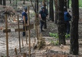 ウクライナ・イジューム近郊にある多数の墓が見つかった森で、地雷を探知する当局者（2022年9月16日撮影）。(c)Juan BARRETO / AFP