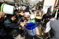 パレスチナ自治区ガザ南部ラファで、食料の配給を待つ人々（2023年12月23日撮影）。(c)MAHMUD HAMS / AFP