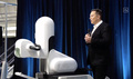 外科手術用ロボットの隣で自身が立ち上げた「ニューラリンク」の技術をプレゼンテーションするイーロン・マスク氏。同社のライブストリーミング配信映像より（2020年8月28日撮影）。(c)AFP PHOTO / NEURALINK