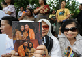 2008年2月28日、タイのバンコク（Bangkok）でタクシン・シナワット（Thaksin Shinawatra）元首相の写真を手に元首相のホテル到着を待つ支持者たち。(c)AFP/Pornchai KITTIWONGSAKUL