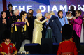 ロンドン（London）のバッキンガム宮殿（Buckingham Palace）で開かれたエリザベス女王（Queen Elizabeth II）即位60年を祝う記念コンサートで、ポール・マッカートニー（Paul McCartney、右から3人目）やエルトン・ジョン（Elton John、右）ら豪華ミュージシャンが見守る中、エリザベス女王の手に口づけをするチャールズ皇太子（Prince Charles、2012年6月4日撮影）。(c)AFP/LEON NEAL