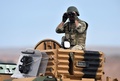 トルコ・シャンルウルファ（Sanliurfa）南東部のムルシトピナル（Mursitpinar）で、シリアのアインアルアラブ（Ain al-Arab、クルド名：コバニ、Kobane）を監視するトルコ軍兵士（2014年10月16日撮影）。(c)AFP/ARIS MESSINIS