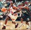 Miami Heat&apos;s guard Tim Hardaway (L) drives to the basket, for two of his 30 points, around Detriot Pistons&apos; guard Lindsey Hunter in second period action of their game 10 April at the Miami Arena. (c)AFP/RHONA WISE