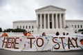 米首都ワシントンの連邦最高裁判所前で横断幕を掲げる活動家ら（2020年6月18日撮影）。(c)NICHOLAS KAMM / AFP