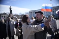 ウクライナ南部クリミア（Crimea）半島のシンフェロポリ（Simferopol）にあるクリミア自治共和国議会議事堂前で、ロシアの国旗を持ち踊る人々（2014年3月17日撮影）。(c)AFP/DIMITAR DILKOFF