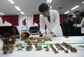 韓国の首都ソウルの西方に位置する仁川で、朝鮮戦争で亡くなった中国軍兵士の遺骨の引き渡し式を控え、机上に並べられる遺骨（2018年3月26日撮影）。(c)AFP PHOTO / Jung Yeon-je