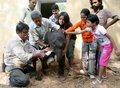 2007年11月15日、インド西部アーメダバード（Ahmedabad）の動物園で、生まれたてのゾウの赤ちゃんに餌を与える飼育員と子どもたち。(c)AFP/Sam PANTHAKY
