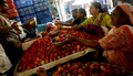 インド・ムンバイ（Mumbai）の市場で、客に野菜を勧める店員（2008年4月12日撮影）。(c)AFP/Pal PILLAI