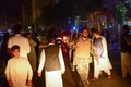 アフガニスタン西部ヘラートで、モスクでの爆発事件の後、路上に立つ人々の中を歩く武装治安要員（2017年8月1日撮影）。(c)AFP/Hoshang Hashimi