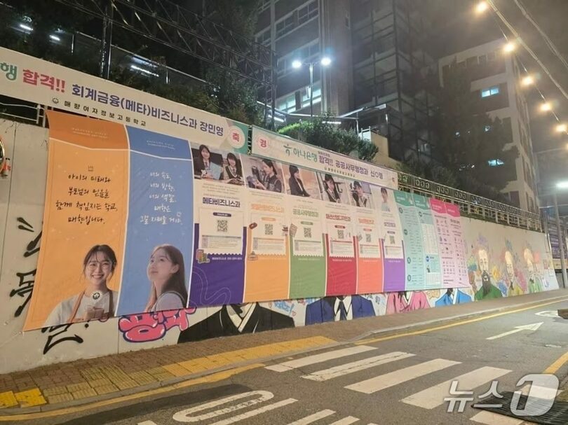 水原梅香女子情報高校の外壁に設けられた「水原独立運動の道」の壁画を覆うように、学校の宣伝用横断幕が掲げられている＝読者提供(c)news1