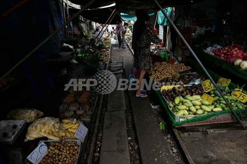 大迫力！露店ぎりぎりを列車が通る、タイ・メークロン市場