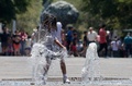 メキシコ・ハリスコ州グアダラハラで、水を浴びて涼む少女（2024年5月23日撮影）。(c)ULISES RUIZ / AFP