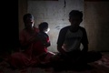 インドネシア・西スラウェシ州マムジュの自宅で子どもを抱く、2018年に結婚した少女（左）と夫（2020年7月22日撮影）。(c)YUSUF WAHIL / AFP