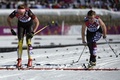 ソチ冬季五輪、クロスカントリースキー女子10キロメートルクラシカルで半袖姿で競技に臨むニコル・フェッセル（Nicole Fessel、ドイツ）選手（左）とノースリーブ姿のセイディー・ビョルンセン（Sadie Bjornsen、米国）選手（2014年2月13日撮影）。(c)AFP/PIERRE-PHILIPPE MARCOU
