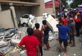 フィリピン・セブ（Cebu）市で、地震で倒壊した建物を見る人々（2013年10月15日撮影）。(c)AFP/Chester Baldicantos