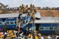 インド・バンガロールから約40キロ離れたアネカル近くで起きた列車の脱線事故の現場で、遺体を搬送する消防隊員と集まった群衆（2015年2月13日撮影）。(c)AFP/Manjunath KIRAN