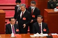 中国・北京の人民大会堂で行われた中国共産党第20回大会閉幕式で、習近平国家主席（右）と李克強首相（左）が席に着く中、介添えを受けて席に向かう胡錦濤前国家主席（中央、2022年10月22日撮影）。(c)Noel CELIS / AFP