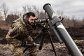 ウクライナ東部のバフムート郊外で、ロシア軍陣地に向けて迫撃砲を発射する準備をするウクライナ兵（2022年12月30日撮影）。(c)Sameer Al-DOUMY / AFP
