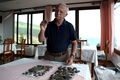 アルバニア南東部にあるオフリド湖畔で発見された考古資料を確認するアルバニア人考古学者のイリル・ジェパリ氏（2023年7月27日撮影）。(c)Adnan Beci / AFP
