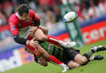 写真はタックルを受けボールをこぼすスペインのダミアン・トレイユ（%%Damien Traille%%、左）。(c)AFP/PIERRE ANDRIEU