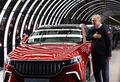 トルコ北西部ブルサ県ゲムリクで開かれた同国初の電気自動車（EV）を開発・生産する合弁企業TOGGの工場開業式に参加し、生産されたEVの横に立って写真撮影に応じるレジェプ・タイップ・エルドアン大統領。トルコ大統領府提供（2022年10月29日撮影）。(c)AFP PHOTO /TURKISH PRESIDENCY PRESS OFFICE