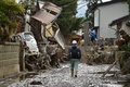 台風19号（アジア名：ハギビス）の影響を受けた長野県で、洪水の被害に見舞われた住宅の脇を歩く男性（2019年10月15日撮影）。(c)Kazuhiro NOGI / AFP