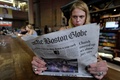 米ボストンの駅でボストン・グローブ紙を読む女性（2018年8月15日撮影）。(c)AFP / Joseph PREZIOSO