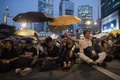 香港（Hong Kong）・金鐘（アドミラルティ、Admiralty）地区で、民主派デモを率いる学生団体の代表と香港政府側の対話の生中継が始まる中、傘を広げるデモの参加者（2014年10月21日撮影）。(c)AFP/Nicolas ASFOURI