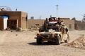 イラクのアンバル州ヒートから数キロ北のモハマディ村で軍の車両の上からVサインを見せる政府の治安部隊員ら（2016年3月18日撮影）。(c)AFP/MOADH AL-DULAIMI