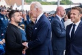 Dデー80年の記念式典が開催された仏ノルマンディーで、握手を交わすウクライナのウォロディミル・ゼレンスキー大統領（左）と米国のジョー・バイデン大統領（中央）。右はフランスのエマニュエル・マクロン大統領（2024年6月6日撮影）。(c)Ludovic MARIN / POOL / AFP