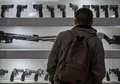 非致死性の銃を見る男性。コロンビア首都ボゴタの販売店で（2021年9月17日撮影）。(c)Juan BARRETO / AFP
