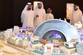 アラブ首長国連邦（UAE）のドバイ（Dubai）が建設を発表した「モール・オブ・ザ・ワールド（Mall of the World）」の模型を見るムハンマド・ビン・ラシド・マクトム（Mohammed bin Rashid Al-Maktoum）・ドバイ首長（左、2014年7月6日提供）。(c)AFP/SHEIKH MOHAMMED BIN RASHID AL-MAKTOUM PRESS OFFICE